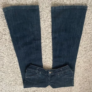 Snygga jeans  - Bilderna är från förra säljaren! Säljer då de är för stora! Jättesnygga låga utsvängda jeans i mörkblå. Inga slitningar. Midjemåttet: 40cm. Grenhöjd: 18cm. Innebenslängden: 80cm. Det är dåligt ljus på sista bilden, färgen är som på de första! Kan gå ner i pris vid snabb affär. Läs bio innan köp! 