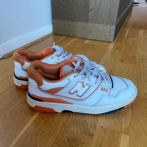 New Balance 550 sneakers - New Balance 550 sneakers i vitt med orange detaljer. Storlek 41.5 köpta från merch of Sweden. Det vi är en special edition.