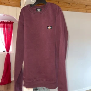 Vinröd sweatshirt från Dickies - Säljer en vinröd sweatshirt från Dickies i storlek medium. Tröjan har en klassisk rund hals och långa ärmar. Perfekt för en avslappnad stil. Den är tillverkad i ett mjukt material för extra komfort.