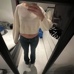 Stickad tröja - Säljer en stilren vit croppad stickad tröja med långa ärmar. Perfekt för en avslappnad look. Tröjan har en enkel design som gör den lätt att matcha med olika outfits.