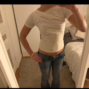Vit omlottopp - vit omlottopp med korta ärmar. Toppen har en tight passform och är perfekt nu till vår o sommar. Den är gjord i ett mjukt och bekvämt material! Som ny utan defekter! 