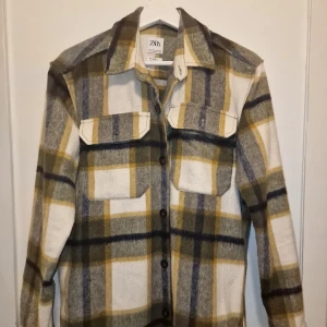 Rutig overshirt från Zara - Snygg rutig overshirt från Zara i gröna, vita och gula toner. Perfekt för lager-på-lager-stil under kyligare dagar.