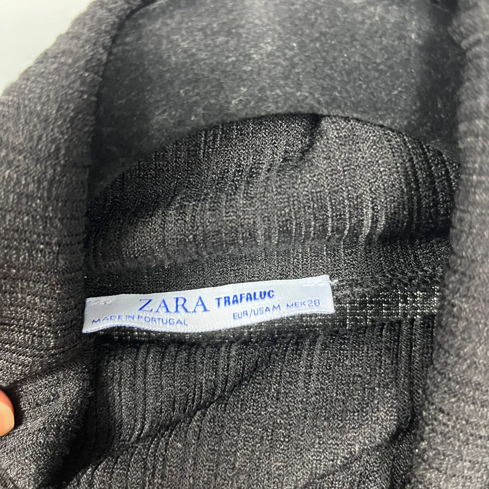 Snygg svart ribbad klänning från Zara med polokrage och långa ärmar. Perfekt för en stilren look. Klänningen är i en bekväm passform och passar bra till kyligare dagar.. Mekot.