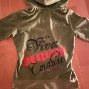 Säljer en supermjuk och snygg grön velourhoodie från Juicy Couture. Den har en dragkedja framtill och en cool text på ryggen. Perfekt för en avslappnad och trendig look. Hoodien har långa ärmar och en huva för extra mysfaktor. Den ger en snatched look i midian eftersom den är rätt liten men strechig så den passar fler storlekar. Skriker Paris Hilton 2000 tal! Säljer eftersom det inte är min stil längre