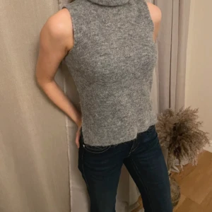 Grå ärmlös polotröja från MSCH - Säljer en supermysig grå ärmlös polotröja från MSCH. För snygg!!!. Alpacka ull så att den är super mjuk och gosig, perfekt för vinter💝💗