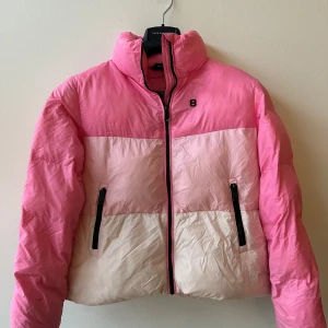 Rosa och vit pufferjacka 8848 Altitude strl 150 - Säljer en superfin rosa och vit pufferjacka i mycket bra skick. 8848 Altitude strl 150. Fickor utanpå. Den har en dragkedja framtill och två praktiska fickor med dragkedjor. Perfekt för kyliga dagar och ger en härlig färgklick till din outfit! Fläck vänster fram, se bild.