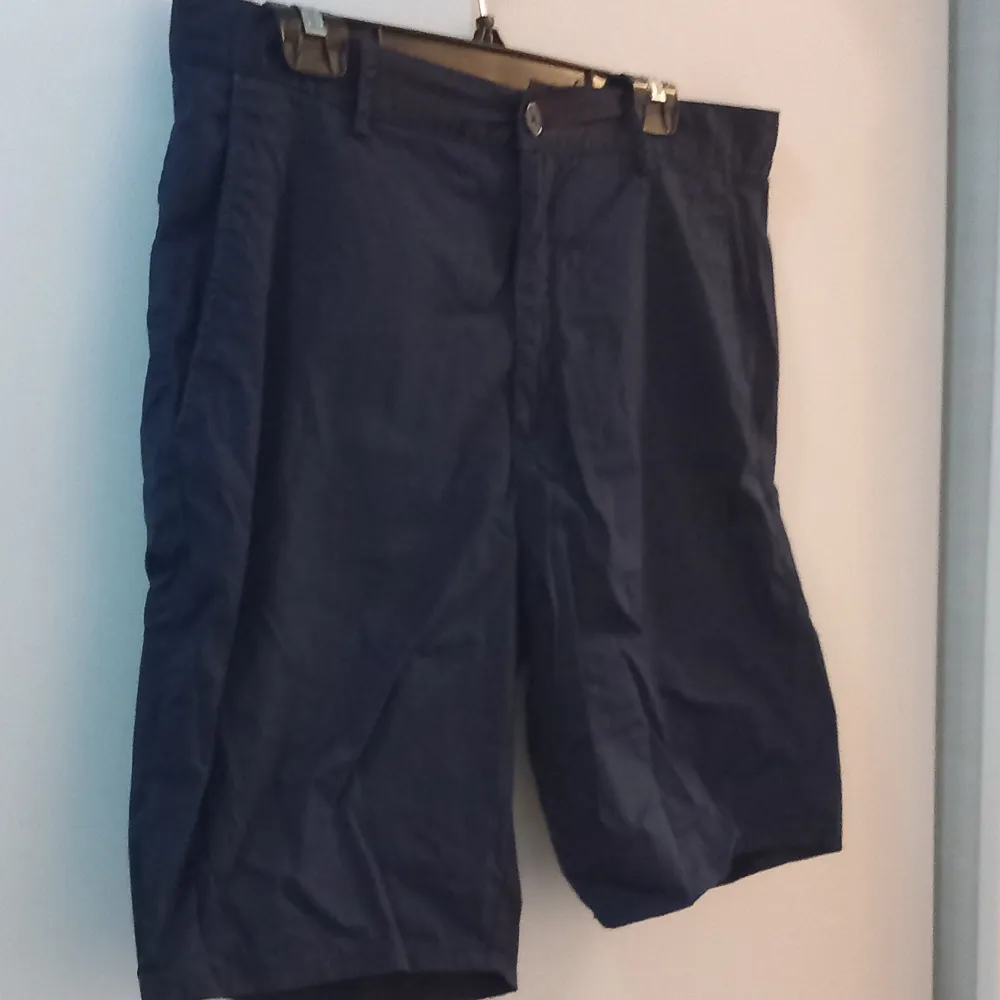 Säljer ett par mörkblå shorts i bra skick. De har en knapp och dragkedja framtill. Perfekta för sommardagar eller en avslappnad vårutflykt. Passformen är normal och de är gjorda i ett lätt och bekvämt material.. Shorts.