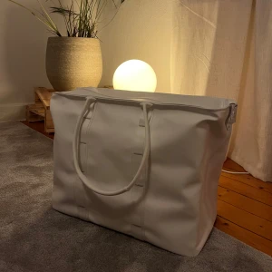 Vit axelväska med dragkedja - Snygg och rymlig vit axelväska. Rymmer 50 litet och är helt oanvänd. 