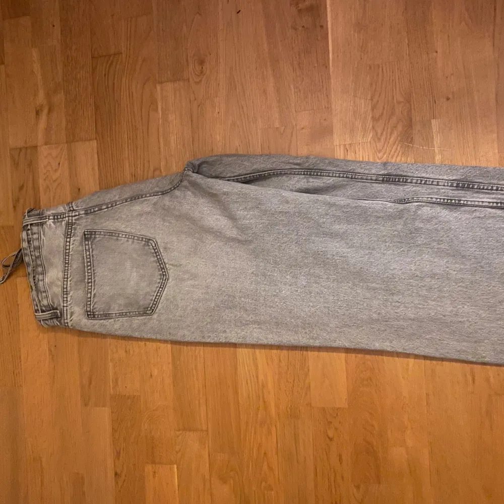 Säljer ett par grå jeans från Gina tricot i storlek 40. De har en loose passform och är medhög midja på, med knytband i midjan. Perfekta för en avslappnad stil och passar till både vardag och fest. 🖤. Jeans & Byxor.