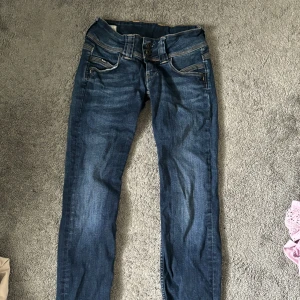 Blå jeans från Pepe Jeans - Säljer ett par snygga blå jeans från Pepe Jeans. De har en klassisk femficksdesign och är i bra skick. Perfekta för vardagsbruk och kan enkelt matchas med olika outfits. Passformen är normal och de har en låg midja. Kontakta för mer💗