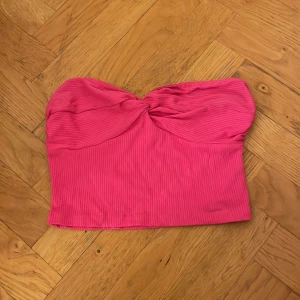 Rosa ribbad tubtopp - Säljer en snygg rosa ribbad tubtopp i mycket bra skick. Toppen har en twistdetalj framtill som ger en fin form och är perfekt för sommardagar eller festkvällar. Den är stretchig och bekväm att bära. Passar perfekt till både jeans och kjol! Köpt på Zara för två år sedan för 299, knappt använd💓