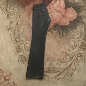 Mörkblå bootcut jeans - Säljer ett par snygga mörkblå bootcut jeans i bra skick. De har en klassisk femficksdesign och är perfekta för både vardag och fest. Jeansen är högmidjade och har en bekväm passform. Perfekta för höst och vår! Dom är också low rist
