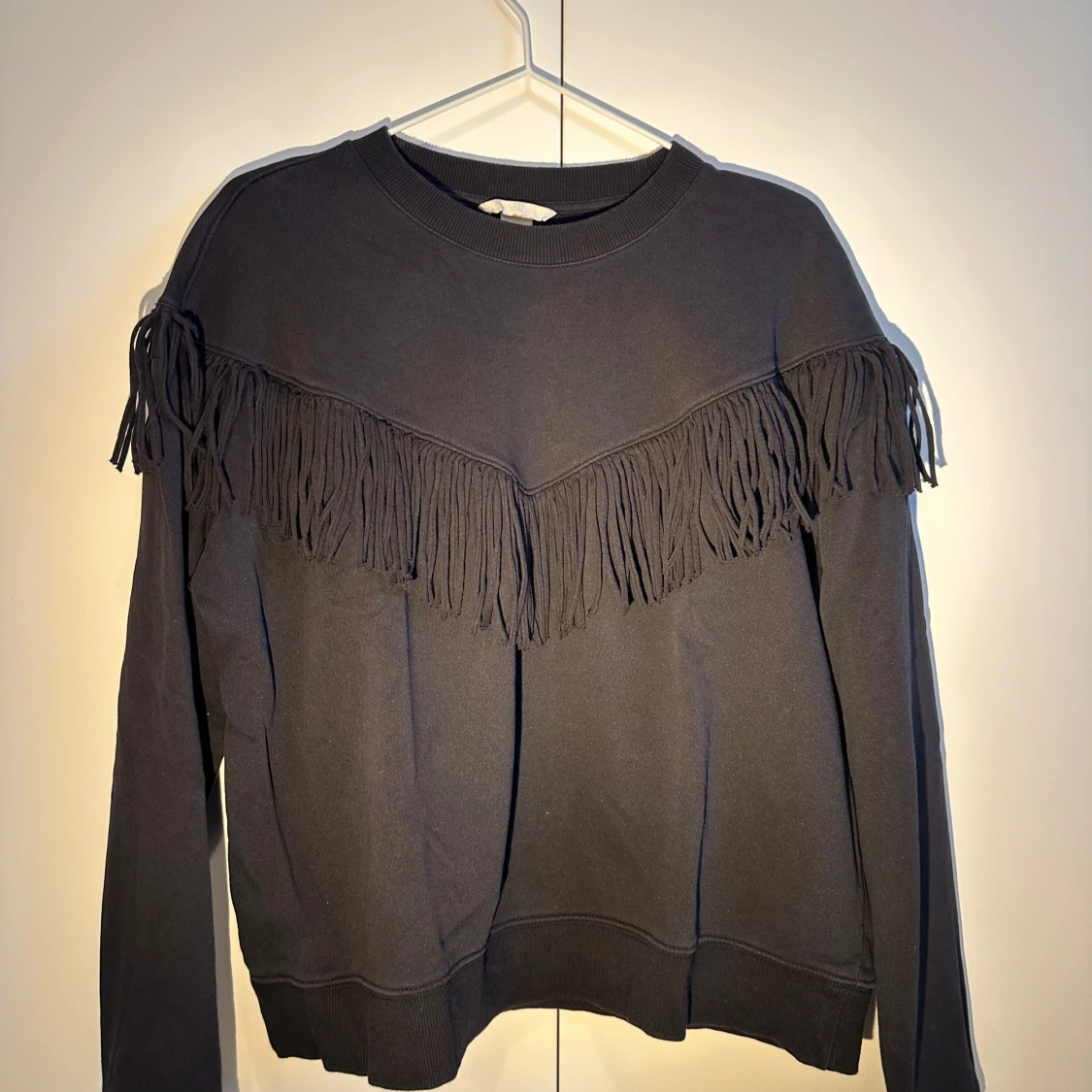 Svart tröja med fransdetaljer