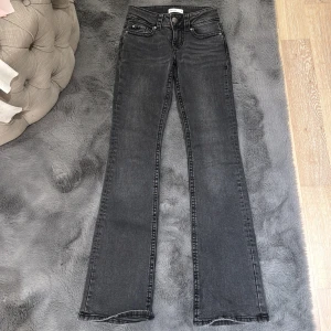 Lowwaist Jeans Ginatricot - Använda 2 gånger så är i mycket bra skick. Stl 32 och har fickor där bak. Gråsvart nyans.💕💕