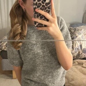 Trekvarts stickad tröja från GinaTricot - Mysig grå stickad trekvarts från GinaTricot. Perfekt för både höst och vår. Den har en enkel och stilren design som passar till det mesta. Tröjan är i nästan helt nytt skick och känns skön mot huden. Storleken är i L, men passar som en xs-m