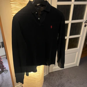 Svart pikétröja från Ralph Lauren - Säljer snygg pikétröja från Ralph lauren som e riktigt najs. Bra skick och men har en del användning på nacken därav de bra priset. Skriv vid frågor!🙌