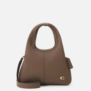 Brun axelväska från Coach - Snygg brun axelväska från Coach i skinn. Den har en unik form med ett stort handtag och en justerbar axelrem. Väskan är stilren med en liten guldfärgad logga på framsidan. Perfekt för både vardag och fest!✨