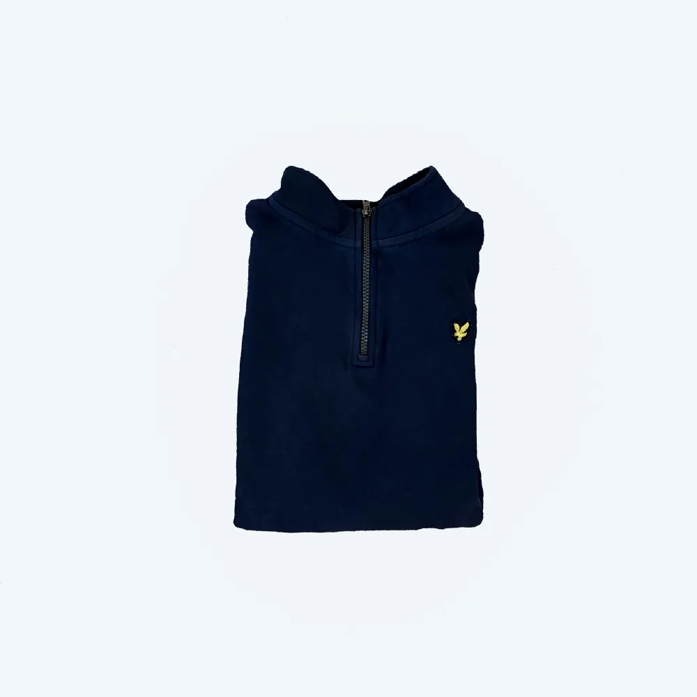 Säljer en snygg mörkblå tröja från Lyle & Scott i juniorstorlek 15/16 år samma som s i storlek. Tröjan har en dragkedja vid halsen och ett litet gult emblem på bröstet. Perfekt för höst och vår, med långa ärmar och en bekväm passform. Passar både till vardags och lite finare tillfällen.. Tröjor & Koftor.