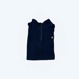 Mörkblå tröja från Lyle & Scott - Säljer en snygg mörkblå tröja från Lyle & Scott i juniorstorlek 15/16 år samma som s i storlek. Tröjan har en dragkedja vid halsen och ett litet gult emblem på bröstet. Perfekt för höst och vår, med långa ärmar och en bekväm passform. Passar både till vardags och lite finare tillfällen.