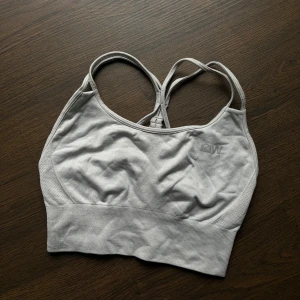 Grå sport-bh från ICIW - Säljer en grå sport-bh från ICIW i mycket bra skick. Den har en snygg och bekväm design med korsade axelband och bred resår under bysten för extra stöd. Perfekt för träning eller vardagsbruk. Materialet är mjukt och stretchigt för bästa komfort.