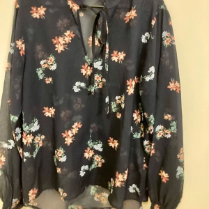 Blus strl M  - Mörkblå blommig blus i storlek M. Material: polyester. Tyget är lite genomskinligt. Mycket fint skick. 