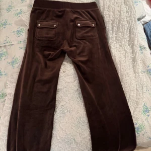  Juicy Couture byxor - Säljer ett par bruna mjukisbyxor från Juicy Couture i storlek M. Finns en matchande tröja till byxorna som kan säljas med vid intresse. 🥰