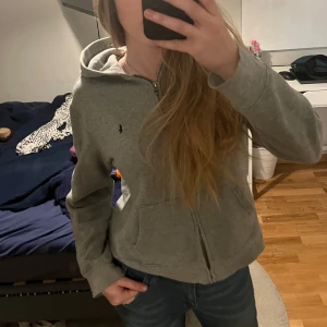 Grå hoodie från Polo Ralph Lauren - Säljer en snygg och bekväm grå hoodie från Polo Ralph Lauren. 