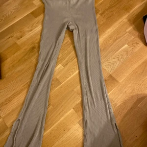 Beige ribbade byxor från H&M - Säljer ett par snygga beige ribbade byxor från H&M i storlek M. D har en tight passform med utsvängda ben.