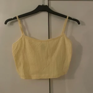 Ribbad croppad linne i gult/blått - Säljer två ribbade linnen tillsammans i härliga färger, ett i ljusgult och ett i ljusblått. Perfekta för sommardagar. De har smala axelband och en croppad passform. Superbekväma och stilrena!