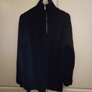 Ribbstickad tröja  - Oanvänd längre modell ribbstickad tröja med dragkedja, hög krage och slits i sidorna. Passar en som har strl M också då den är stor I storleken  Bla är det detta material i tröjan.