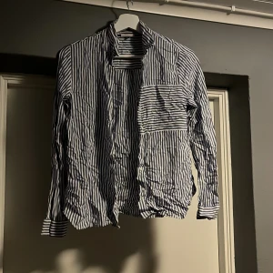 Randig skjorta från Street One - Säljer en snygg blå- och vitrandig skjorta från Street One i storlek S. Skjortan har långa ärmar och en klassisk krage, perfekt för både vardag och fest. Den är i bra skick och redo för en ny ägare. Passar perfekt till jeans eller kjol för en stilren look!