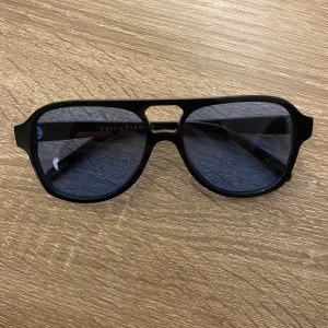 Svarta och blåa solglasögon från Corlin Eyewear - Snygga svarta och blåa solglasögon från Corlin Eyewear i ett klassiskt pilotformat. De har en robust svart ram och mörka linser som ger ett coolt och stilrent intryck. Perfekta för både vardag och fest! Kommer med ett matchande svart fodral för säker förvaring.