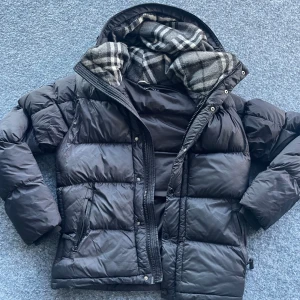 Svart pufferjacka från Burberry - Säljer en snygg och varm svart pufferjacka från Burberry. Den är i xxl men passar L. Vid snabb affär kan jag tänka mig gå ned i pris.Om du undrar något mer är de bara att skriva!