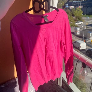 Rosa kofta med knappar  - Superfin rosa v-ringad kofta med små rosa knappar framtill.  Stl xs/s från hm  I fint skick 