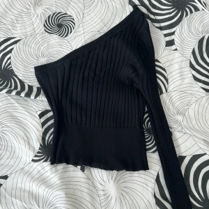 Svart enarmad tröja - Tröjan är ribbad och enarmad, använd en gång