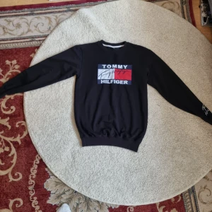 Svart tröja från Tommy Hilfiger - Säljer en snygg svart tröja från Tommy Hilfiger i storlek XL.  Den är långärmad och perfekt för en casual look. Passar bra till både jeans och joggers!