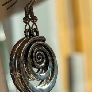 Silvriga spiralformade örhängen - Coola silvriga örhängen med en unik spiraldesign. De är gjorda av metall och har en glansig yta som fångar ljuset snyggt.NY Jag har börjat sälja min smyckessamling, så jag uppdaterar ofta här på Plick Postar inom tre dagar efter köpet Gotiska Y2K 