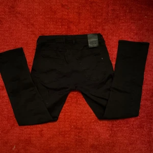 Svarta jeans från Replay - Snygga svarta jeans från Replay modell straight grover. De har en rak passform och är tillverkade i ett bekvämt material. Jeansen är bara använda 2 gånger vilket gör att de är i ny skick utan defekter. Nypris:1600