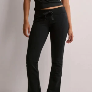 Svarta mjukisbyxor med knytband - Lågmidjade mjukisbyxor från Nelly som aldrig är Andvänd då jag köpte fel storlek!❤️