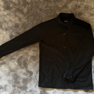 Svart overshirt från Brave Soul - Snygg svart overshirt från Brave Soul i storlek S. Sparsamt använd och ett riktigt bra plagg nu till våren! Nypris ca 500kr men nu endast 120kr!