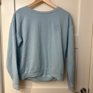 Ljusblå sweatshirt från Roxy - Säljer en ljusblå sweatshirt från Roxy med broderad logga på bröstet. Tröjan har långa ärmar och en rund halsringning. Perfekt för en avslappnad stil. 💙