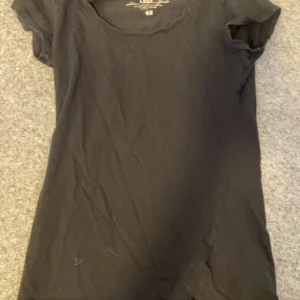 Svart t-shirt från H&M - Säljer en klassisk svart t-shirt från H&M. Den har en rund halsringning och korta ärmar, perfekt för en enkel och stilren look. Passar till det mesta och är ett måste i garderoben.