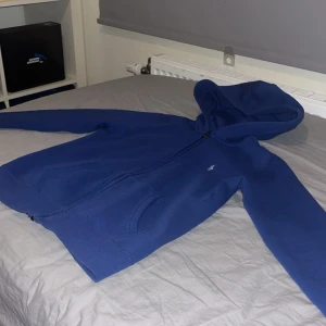 Blå hoodie från Polo Ralph Lauren - Säljer en snygg blå hoodie från Polo Ralph Lauren. Den har en dragkedja framtill och en praktisk huva. Perfekt för en avslappnad stil. Märketikett och prislapp kvar.