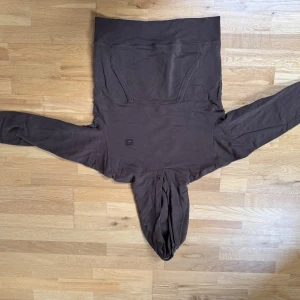 Brun hoodie från Acne Studios - Säljer en stilren brun hoodie från Acne Studios. Den har en klassisk design med en stor ficka framtill och en bekväm huva. Perfekt för en avslappnad look. Storlek S.