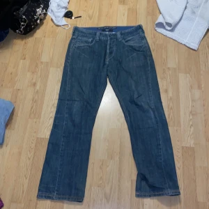 Blå jeans från Levi's - Säljer ett par klassiska blå Levi's jeans med bootcut-stil, står de är straight men är aning bootcut på mig iallafall. Midja - 42cm. Längd - 105cm.  Innerbenslängd - 77cm. Inget fel på dessa förutom litet slitage på sista bilderna. Köpta för 700, pris går att diskuteras.
