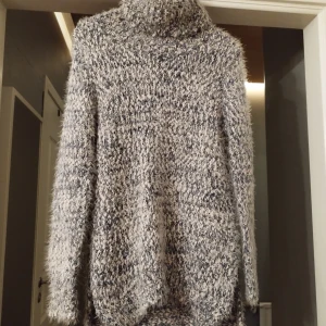 Mönstrad stickad tröja från Crocker Apparel - Säljer en mysig och varm stickad tröja från Crocker Apparel i storlek XS. Tröjan har ett unikt mönster i grått och vitt med en hög krage och långa ärmar. Perfekt för kyliga dagar.