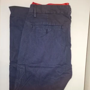 Mörkblå byxor från Acne Jeans - Snygga mörkblå byxor från Acne Jeans i 100% bomull. Perfekta för en stilren look. Kostade runt 1200 kr vid inköp och är sparsamt använda. Garderobsrensning så kika gärna på övriga auktioner. 