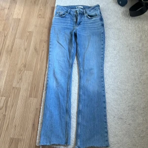 Perfekt jeans från Gina Tricot - Snygga ljusblå jeans från Gina Tricot med bootcut-stil. De har en klassisk femficksdesign och en bekväm passform. Perfekta för en avslappnad look.