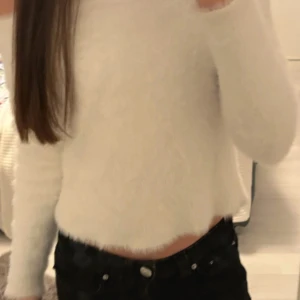 Vit fluffig tröja - Säljer en supermjuk och fluffig vit tröja med lång ärm. Perfekt för att hålla sig varm och mysig. Tröjan har en croppad passform som ger en offshoulder look. Passar perfekt till jeans eller kjol. Står att tröjan är i storlek M men är rätt tight och kort! Kontakta om du är intresserad! (har även ett litet hål på armen men syns knappt)