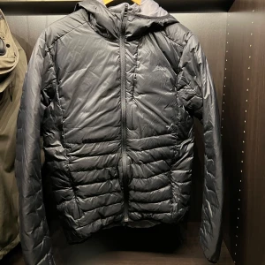 Svart quiltad dunjacka med huva  - Säljer en stilren svart quiltad dunjacka med huva från Everest. Jackan har en dragkedja framtill och är perfekt för kyligare dagar. Den är långärmad och har en modern passform.